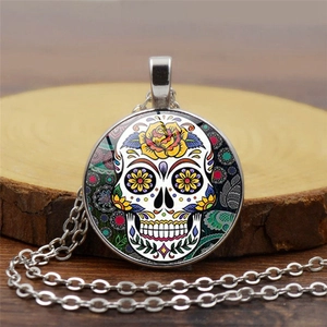 Detail of vintage silver sugar skull pendant with colorful floral patterns and glass dome