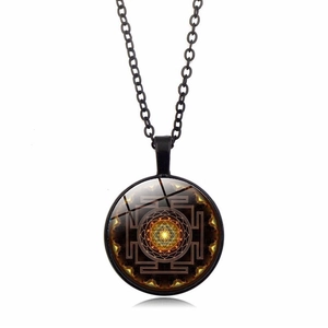 Détail d'un collier chaîne en métal noir avec pendentif géométrique sacré Sri Yantra