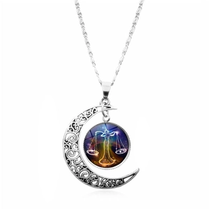 Detail view of silver crescent moon necklace featuring a Libra constellation glass gem