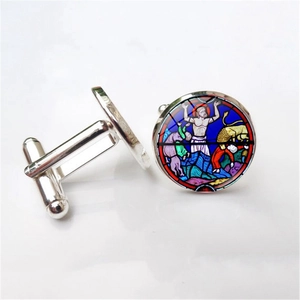 Detailed macro view of silver-tone cufflinks featuring colorful rose window glass art