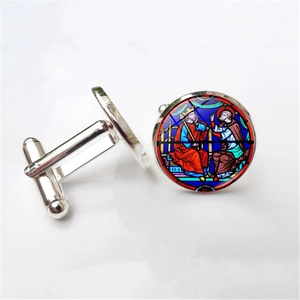 Detailed macro view of silver cufflinks featuring medieval stained glass art pattern