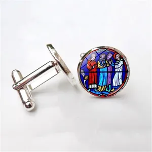 Detail of silver round cufflinks with religious stained glass art and polished finish