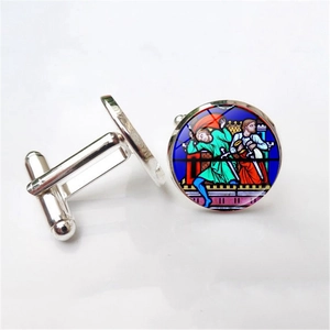Macro detail of silver bullet back cufflinks featuring colorful stained glass rose patterns