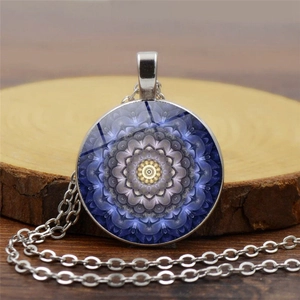 Gros plan du collier Mandala en verre avec motifs bleus sur support en bois naturel