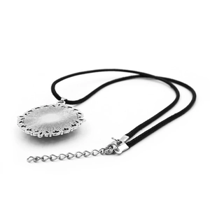 Detail of the silver matryoshka pendant back with radial pattern and adjustable wax cord