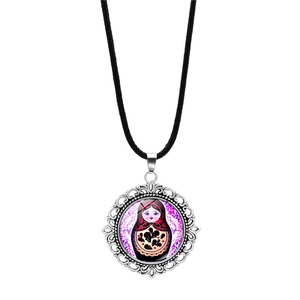 Detailed macro view of a vintage Russian nesting doll glass pendant with silver frame