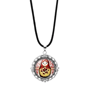Macro detail of Russian doll pendant necklace with silver floral metal frame and glass dome