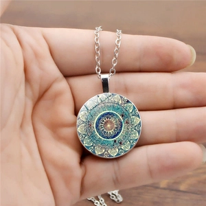 Détail du collier pendentif en verre Mandala avec motif géométrique turquoise et doré fin