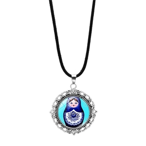 Detail of silver filigree pendant with Russian nesting doll glass cabochon and black cord