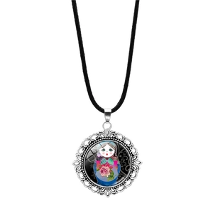 Detail of vintage silver pendant with Russian nesting doll pattern and floral hollow frame