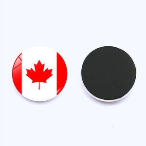 Macro detail of round Canada flag magnetic fridge sticker showing red maple leaf design