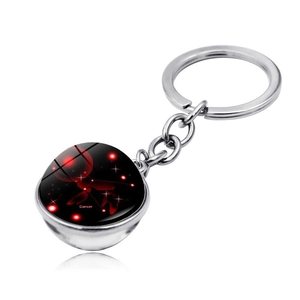 Macro detail of silver Cancer zodiac keychain with a double-sided glowing crystal ball