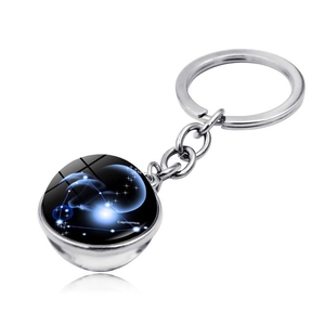 Macro shot of Capricorn zodiac double-sided crystal ball pendant keychain on silver chain