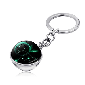 Detailed macro view of Sagittarius double-sided crystal ball keychain on white surface