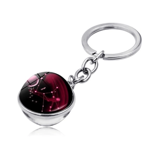Detail of silver Virgo zodiac keychain with a double-sided red nebula crystal ball