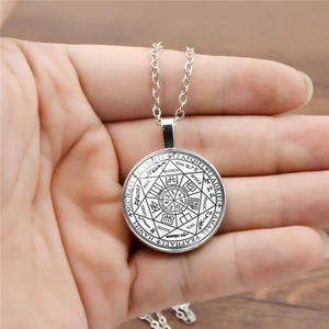 Gros plan du pendentif sceau d'archange en argent avec gravures Gabriel et Michael