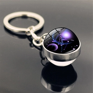 Macro detail of Libra constellation glass ball keychain with silver metal base and ring