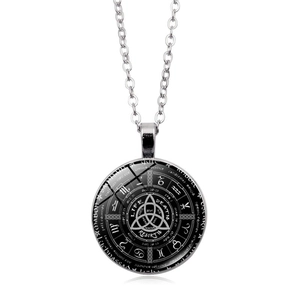 Detail of silver astrology pendant with Triquetra symbol and Life Death Rebirth engraving