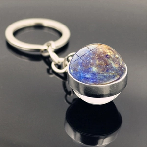 Macro side view of Mercury planet glass pendant with polished metal keychain and reflection
