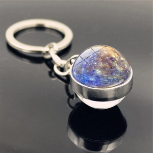 Macro shot of double-sided glass galaxy pendant keychain with blue-purple nebula design