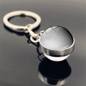 Macro view of moon glass dome pendant keychain with detailed lunar surface and silver base