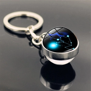 Close-up of Taurus constellation glass sphere keychain with glowing blue nebula effect