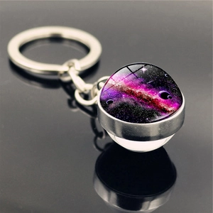 Macro view of the solar system galaxy nebula glass ball keychain on a dark mirror surface