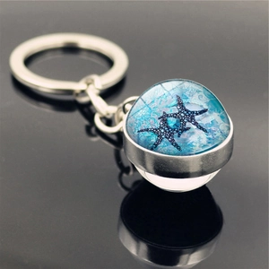 Macro shot of silver keychain with blue crystal ball featuring a sea star pattern