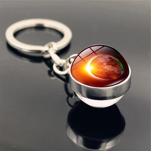 Macro shot of solar system galaxy glass pendant keychain on reflective mirror surface