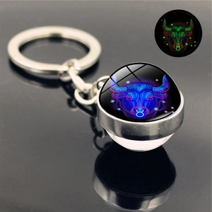 Macro detail of Taurus zodiac keychain showing its glowing neon crystal ball and metal ring