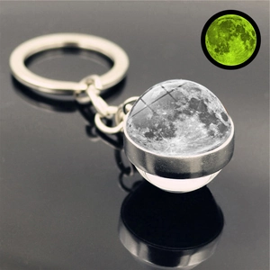 Detailed close-up of a luminous moon crystal ball keychain with glow-in-the-dark effect