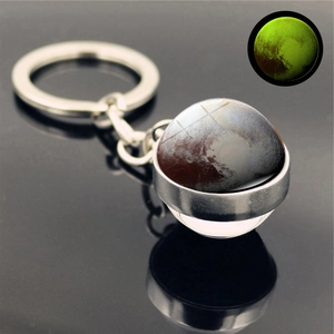 Luminous Pluto double-sided glass ball keychain showing glowing effect in the dark