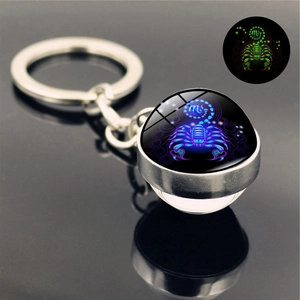 Macro detail of Scorpio crystal ball keychain with glowing luminous effect in darkness