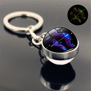 Macro shot of luminous Sagittarius glass ball keychain with silver metal ring