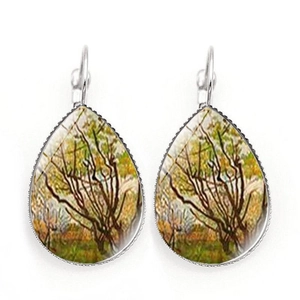 Close-up of teardrop earrings with Van Gogh style painting and silver metal frame