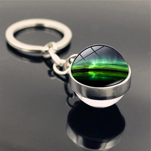 Macro shot of silver metal keychain with double-sided crystal glass aurora borealis pendant