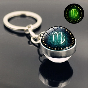 Macro view of Virgo glowing keychain with glass orb and luminous constellations