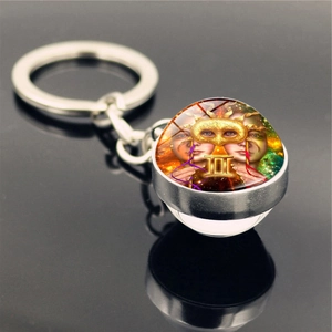 Macro shot of silver Gemini constellation keychain with artistic double-face glass pendant