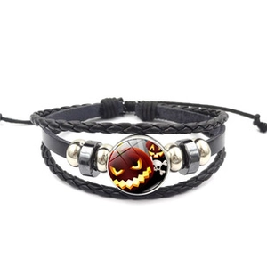 Close-up of Halloween leather bracelet with pumpkin and skull glass dome ornament