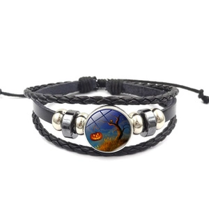 Detail of multi-layer leather bracelet with Halloween pumpkin glass cabochon charm