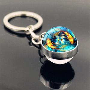 Macro shot of double-sided glass keychain featuring Pisces zodiac sign and koi fish design