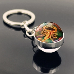 Macro shot of Scorpio zodiac glass ball keychain with starry nebula design and metal ring