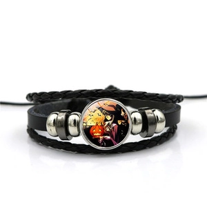 Detail of multi-layer woven leather bracelet featuring Halloween wizard and pumpkin gemstone