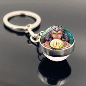 Double-sided glass ball Virgo zodiac keychain with silver metal ring on black background