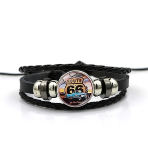 Detail of multi-layer braided leather bracelet with vintage Route 66 glass cabochon charm