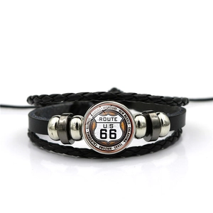 Macro shot of Route 66 glass cabochon on black multilayer leather braided bracelet