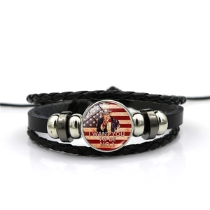 Detailed macro of the woven leather bracelet featuring Uncle Sam and US flag glass charm