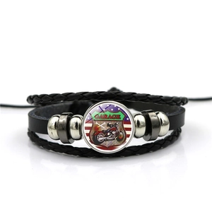 Detail of multi-layer leather bracelet with vintage motorcycle glass dome charm and beads
