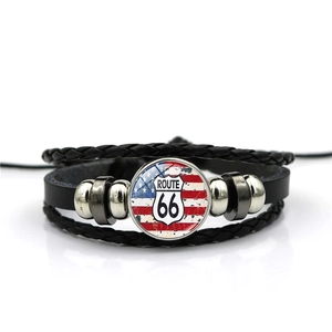 Macro detail of multilayer braided leather bracelet with Route 66 glass gem and US flag