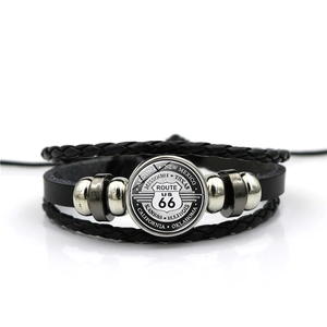 Macro detail of the Route 66 glass gem on a multilayer leather woven bracelet